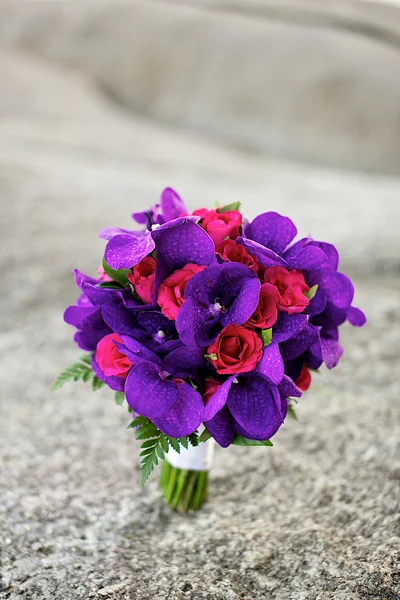 Ramo de flores de rosas y orquídeas en la roca —  Fotos de Stock