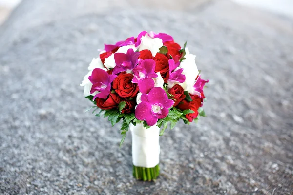 Rose e flor de orquídea buquê de casamento na rocha — Fotografia de Stock