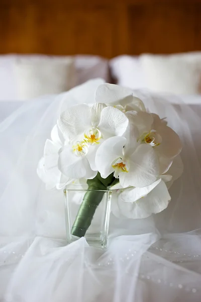 Biała orchidea wesele bukiet na łóżku — Zdjęcie stockowe