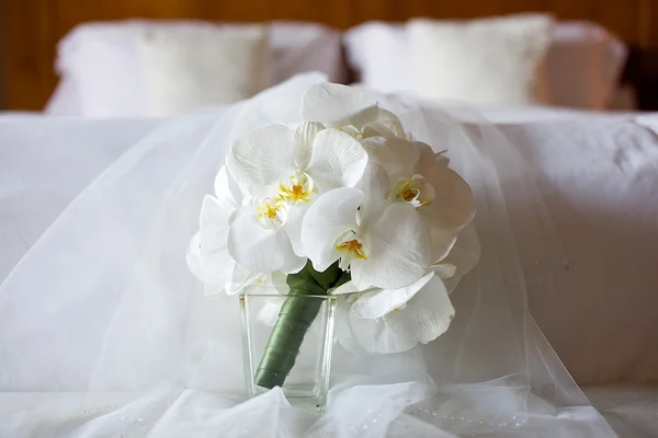 Buquê de casamento de orquídea branca na cama — Fotografia de Stock