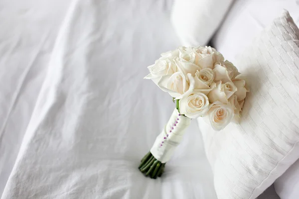 Weiße Rose Hochzeitsstrauß auf dem Bett — Stockfoto
