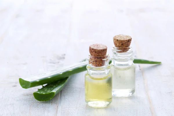 Färsk aloe vera med aromaolja på trä bakgrund — Stockfoto