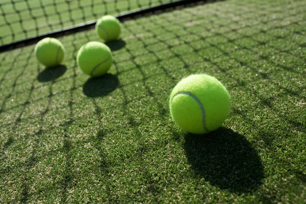 Tennis balls on tennis grass court — Stock Photo, Image