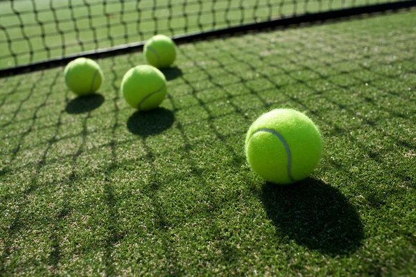 Tennis balls on tennis grass court — Stock Photo, Image