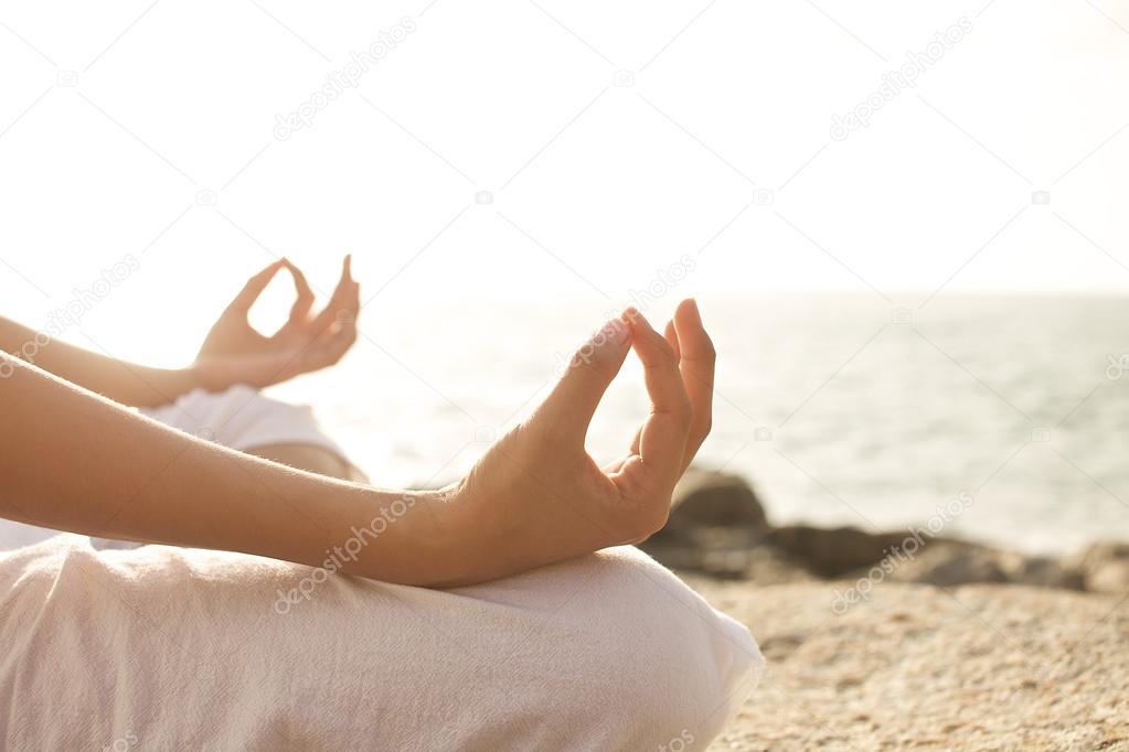Young woman meditation yoga pose on the beach