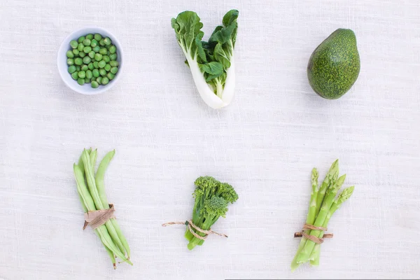 Verse groene groenten verscheidenheid op rustieke witte achtergrond van t — Stockfoto