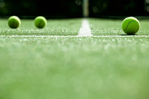 Tennis balls on tennis grass court — Stock Photo, Image