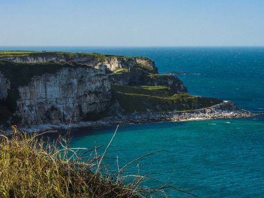 Bir yaz günü Kuzey İrlanda 'nın beyaz kayalıklarında dalgalar çarpışıyor.