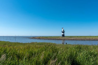Wremen 'deki deniz feneri Küçük Prusyalı ile kıyı manzarası. Wremen, Almanya 'nın Kuzey Denizi kıyısındaki Doğu Frizya' da bulunur..