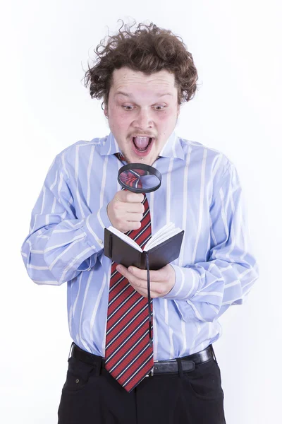 Man with magnifying glass reading book — Stock Photo, Image