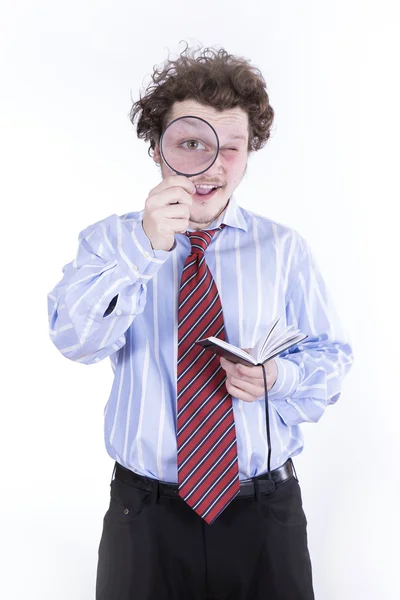 Man with magnifying glass reading book Stock Photo