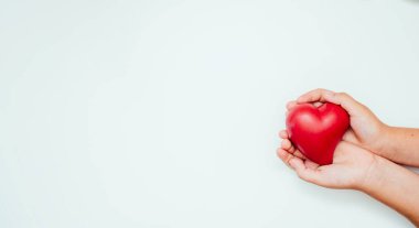 Çocuk holding kırmızı kalp eller