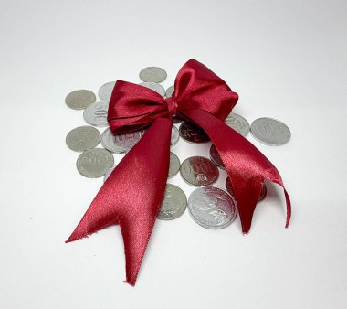 Üstünde kurdele olan sikkeler maddi ödülü ya da maddi hediyeyi simgeliyor.