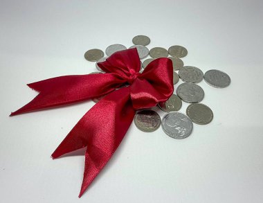 Kırmızı Saten Yay ve Gümüş Paralar Finansal Hediye veya Ödül, Endonezya Parası 'nı temsil ediyor.