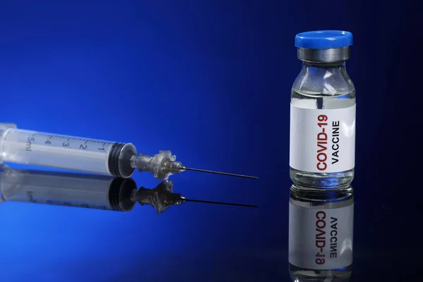 蓝色底色的注射器和疫苗 — 图库照片