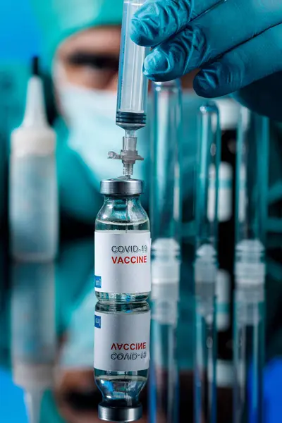 医師の手によるコロナウイルスワクチンと注射器 — ストック写真