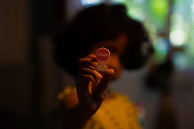 Elinde dur işareti tutan bir çocuk.