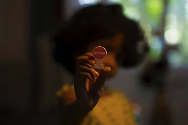 Elinde dur işareti tutan bir çocuk.