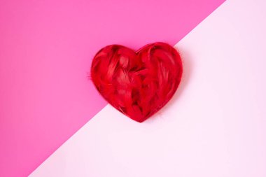 Kırmızı tüylü kalp mor ve pastel pembe arka planda. Mutlu.