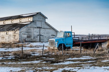 Calgary, Alberta, Kanada, 17 Nisan 2013. Eski, terk edilmiş bir Ford kamyonu, Calgary 'nin hemen dışındaki terk edilmiş bir ahırın yanında, bir çiftliğin bahçesinde paslanıyor.