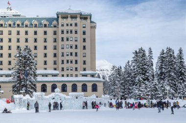 Banff Ulusal Parkı, Alberta, Kanada 'da donmuş Louise Gölü' nde buz pateni yapan turistler
