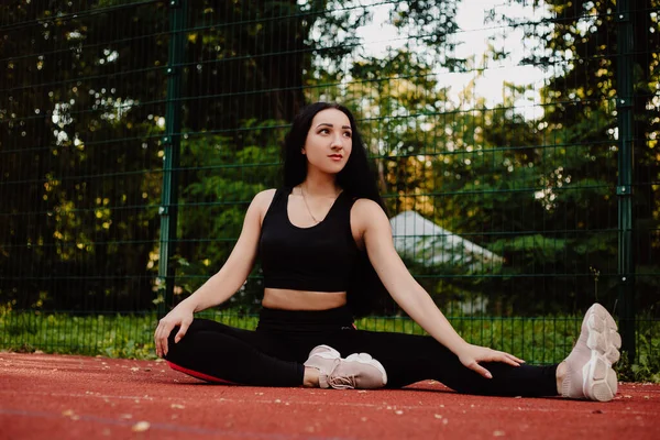 Spor kıyafetleri giyen spor kızı sokakta yoga egzersizi yapıyor, açık hava sporları, şehir tarzı.
