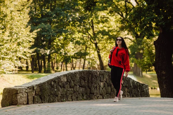 Spor kıyafetleri giyen spor kızı sokakta yoga egzersizi yapıyor, açık hava sporları, şehir tarzı.