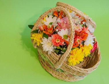 Açık renkli arka planda çiçekli hasır sepet. Tatiller ve selamlar