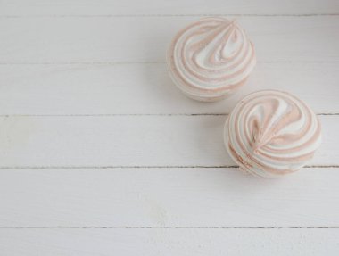 Beyaz ahşap arka planda sarı boklu kahve marşmelovu. Bayram için hafif tatlı.