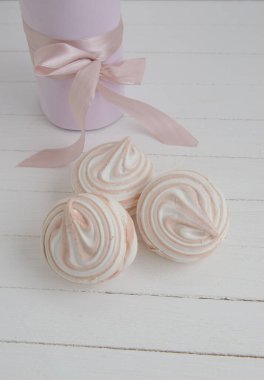 Beyaz ahşap arka planda sarı boklu kahve marşmelovu. Bayram için hafif tatlı.