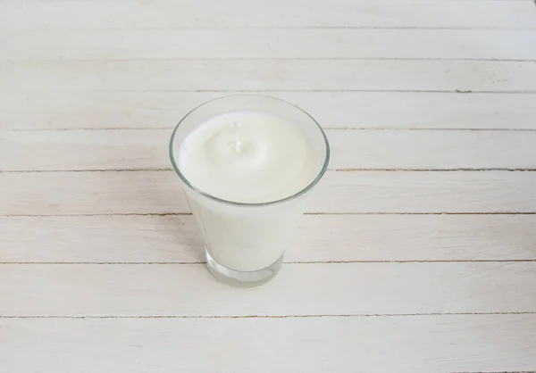 Beyaz Inek Sütü Arka Planda Berrak Bir Bardakta Damlalar — Stok fotoğraf