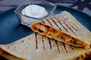 Siyah tabakta etli ve sebzeli sandviç.