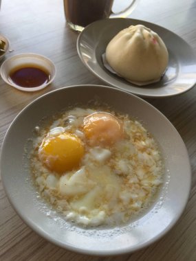 Asya kahvaltısı karabuğday çöreği, kaynamış yumurta, kavrulmuş ballı tatlı sos ekmeği ve konsantre sütle birlikte kahve..