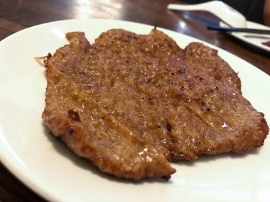 Dilimlenmiş domuz pirzolası Tayvan ya da Çin restoranında beyaz bir tabakta servis edilir..