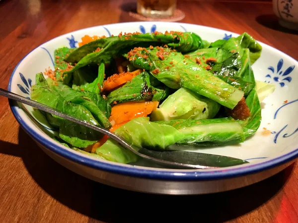 Asya yemeği, kızarmış kailan, havuç ve deniz kulağı soslu domuz rostosu. Tayland restoranında servis yap. Kızarmış sarımsak serpin..