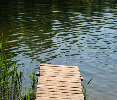 Yazın sakin bir gölette küçük bir iskele.