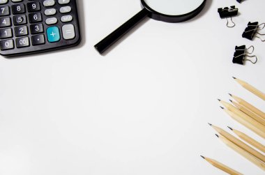 Hesap makinesi büyüteç beyaz arkaplanda yatar. Eğitim konsepti, iş. yazılacak yer