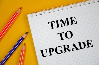 Renkli kalemler ve sarı arkaplan ile beyaz bir not defterine yazılmış metni güncelleme zamanı