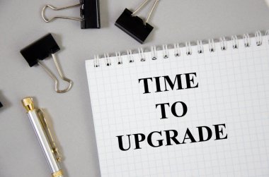 Metni güncelleme zamanı, kalemlerle gri bir arkaplan üzerine uzanan beyaz bir sayfa üzerine yazılır