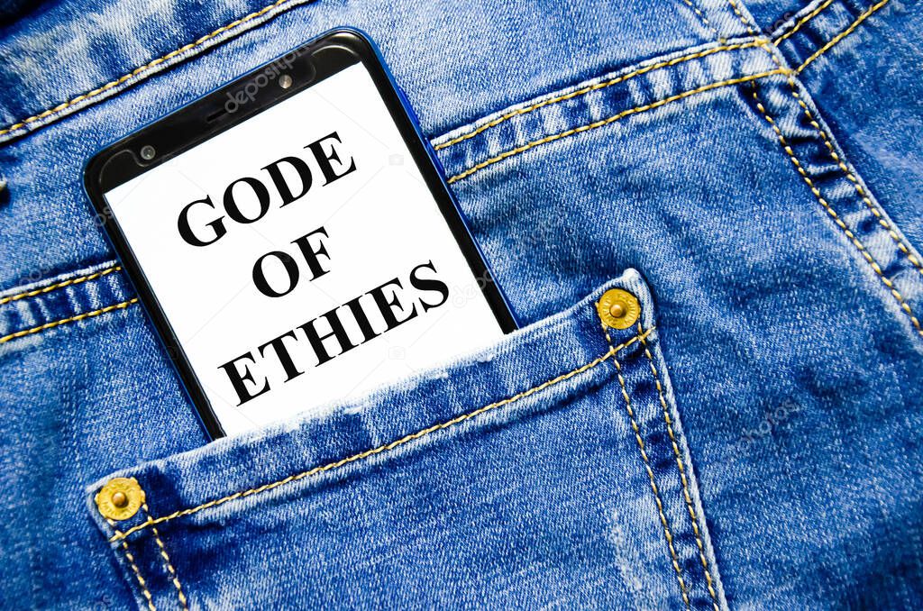 Code of ethics symbol. the text is written on the white screen of the phone shortly lies in jeans. text