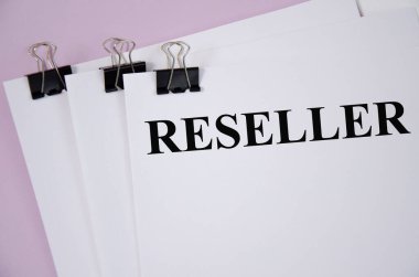 beyaz bir kağıt parçası ve pembe bir arkaplan üzerine yazılmış reseller metin