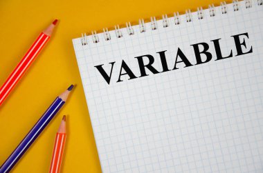 Beyaz not defterinde ve sarı arkaplanda yazan değişken. kelime