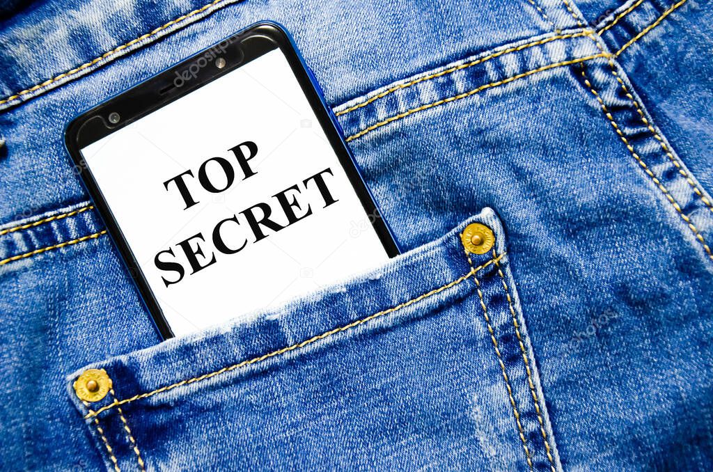 Top Secret the text is written on the white screen of the phone shortly lies in jeans