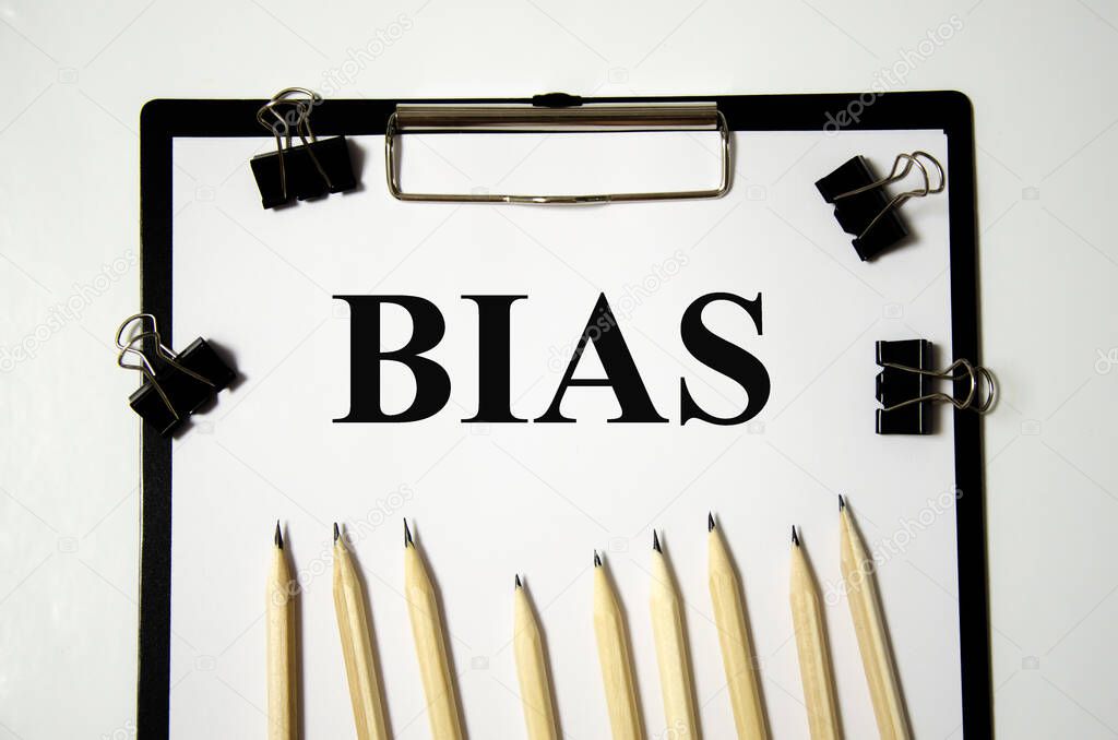 bias the word is written on a white piece of paper with pencils