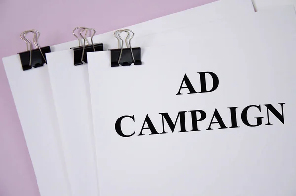 Beyaz kağıt ve pembe arkaplan üzerine yazılmış reklam kampanyası kavramı