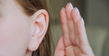 Kız elini kulağına koydu. Kız bizi dinliyor. Kızın kulağı ağrıyor. Kızda kulak hastalığı var..