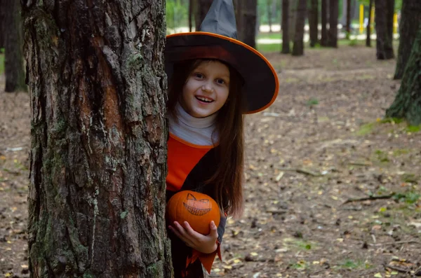 Cute Girl Looks Out Tree Holds Pumpkin Her Hands — Stockfoto