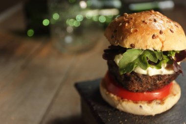 Kalın etli, peynirli, sebzeli ve limonlu hamburger.