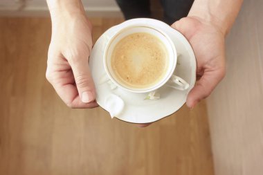 Bir fincan kahveli eller. 