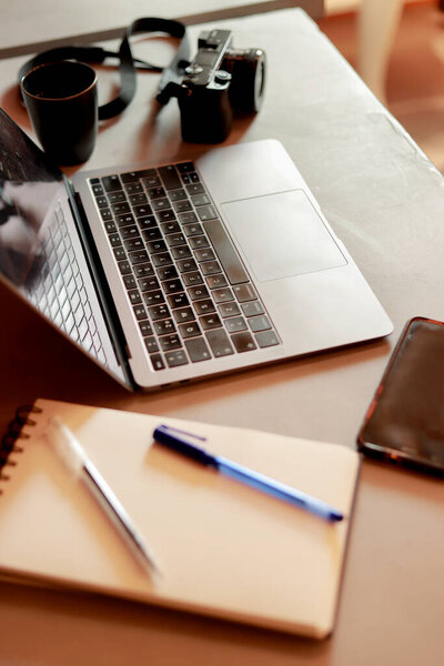 рабочий стол офиса фотографа с ноутбуком и блокнотом